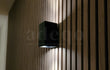 Close-up van Adeqo akoestisch wandpaneel in Licht Walnoot met moderne zwarte wandlamp.