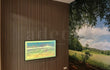 Wanddecoratie met Adeqo akoestisch wandpaneel in Licht Walnoot naast grote natuurmuurprint.