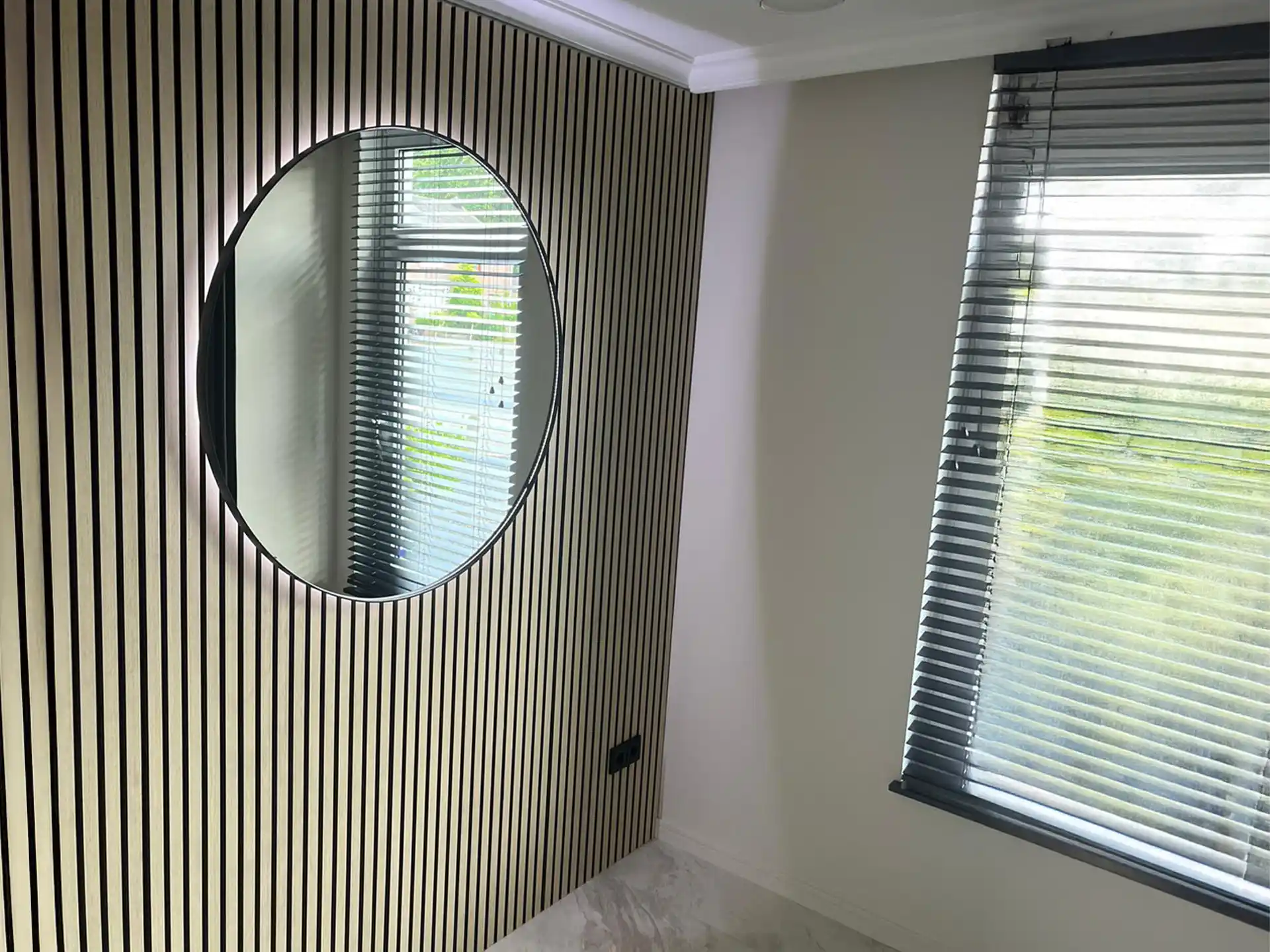 Kamer met ronde spiegel en Adeqo akoestisch wandpaneel in Natuurlijk Eiken voor een moderne uitstraling.