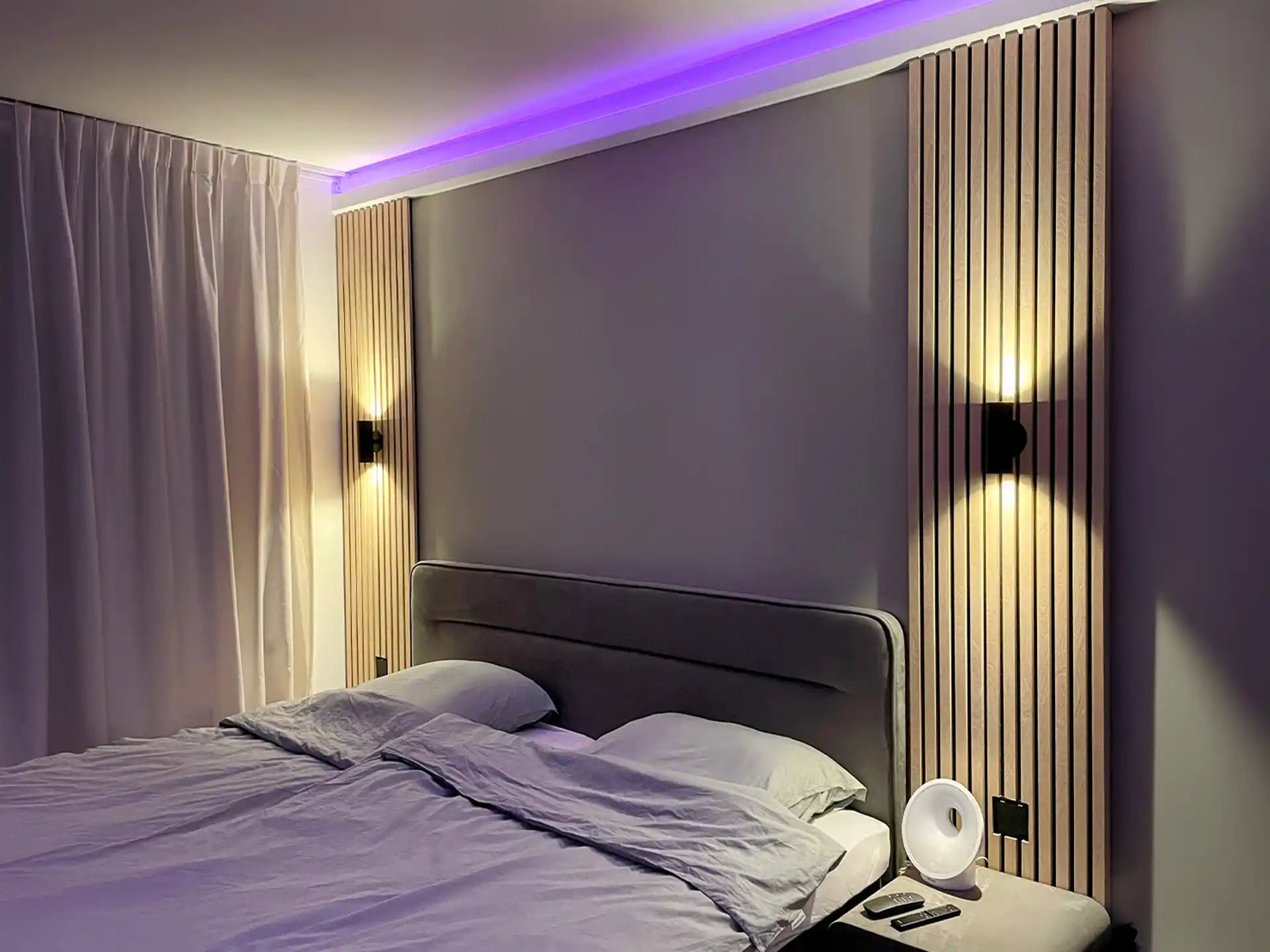 Slaapkamer met Adeqo akoestisch wandpaneel in Natuurlijk Eiken, sfeerverlichting en modern bed.