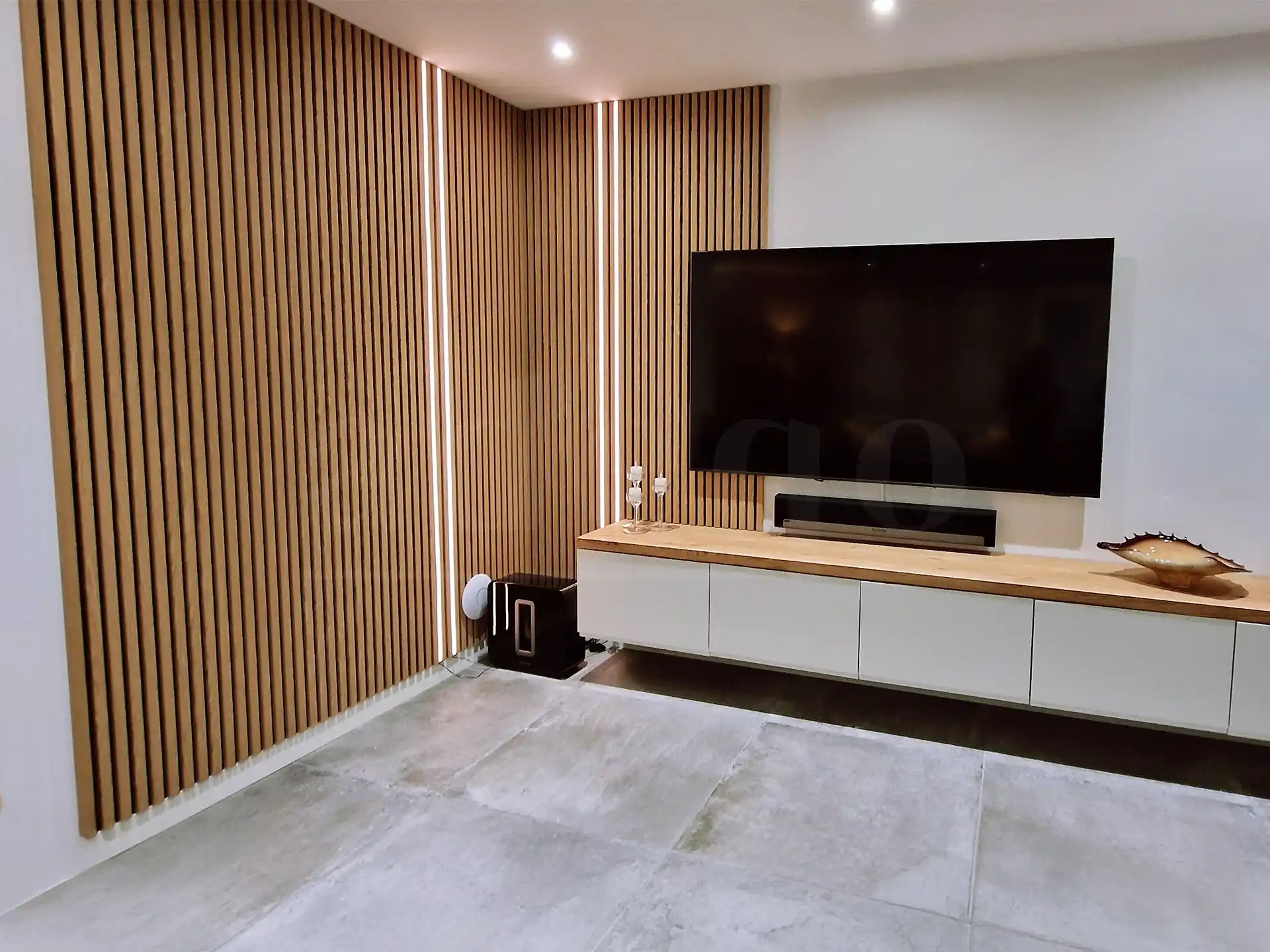 Tv-wand met Adeqo akoestisch wandpaneel in Rustiek Eiken en verticale ledverlichting.