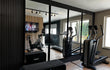 Akoestische wandpanelen in Zwart Eiken in een luxe thuisgym, gecombineerd met grote spiegels en fitnessapparatuur voor een stijlvolle en geluidsdempende sportruimte.