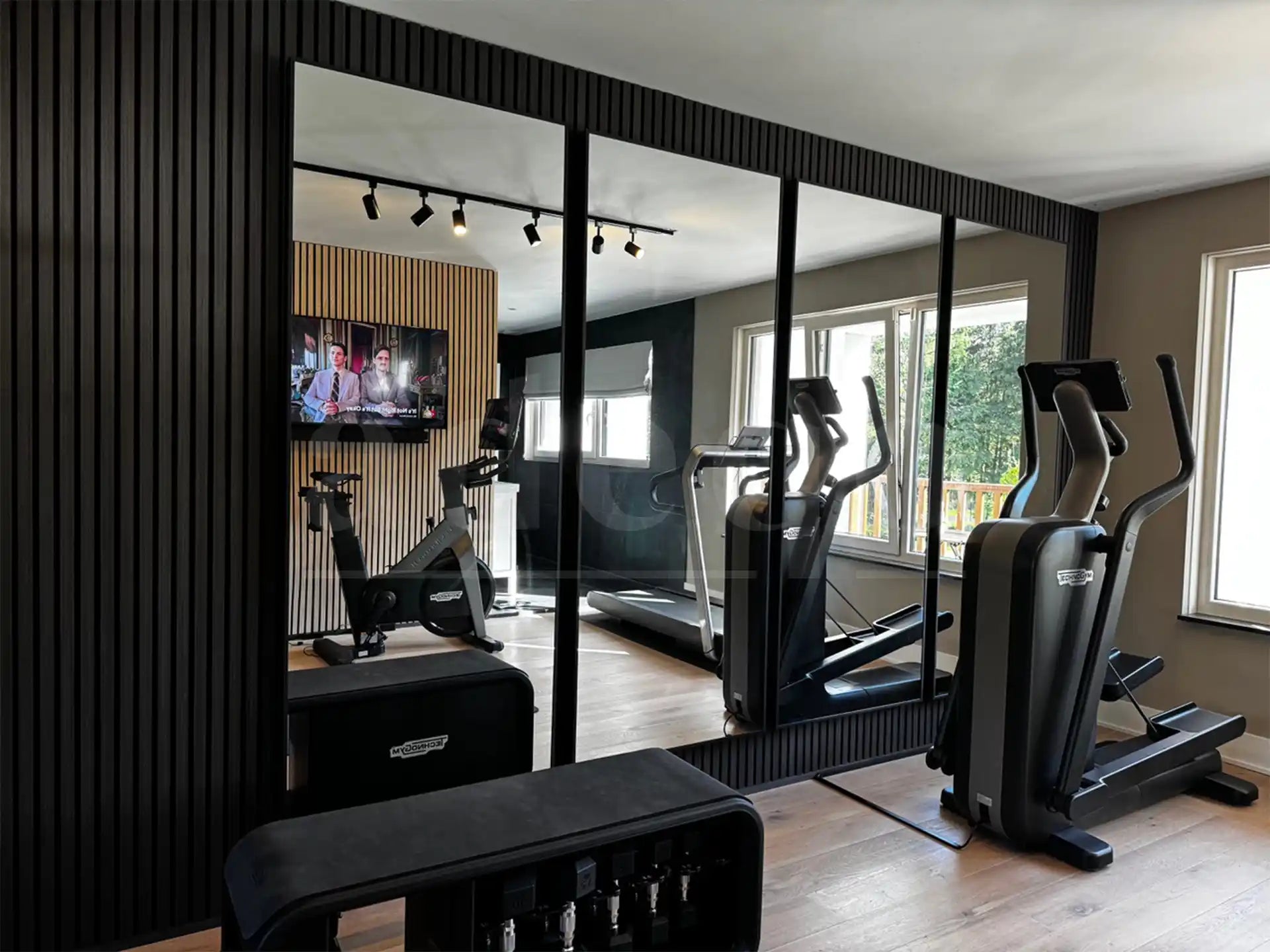 Akoestische wandpanelen in Zwart Eiken in een luxe thuisgym, gecombineerd met grote spiegels en fitnessapparatuur voor een stijlvolle en geluidsdempende sportruimte.