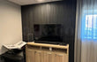 Akoestische wandpanelen in Zwart Eiken als tv-achterwand in een moderne woonkamer, gecombineerd met een houten tv-meubel en neutrale gordijnen.