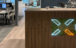 Kast bekleed met bruine eiken akoestische wandpanelen van Adeqo, voorzien van geïntegreerde ledverlichting en een decoratief mosaccent.