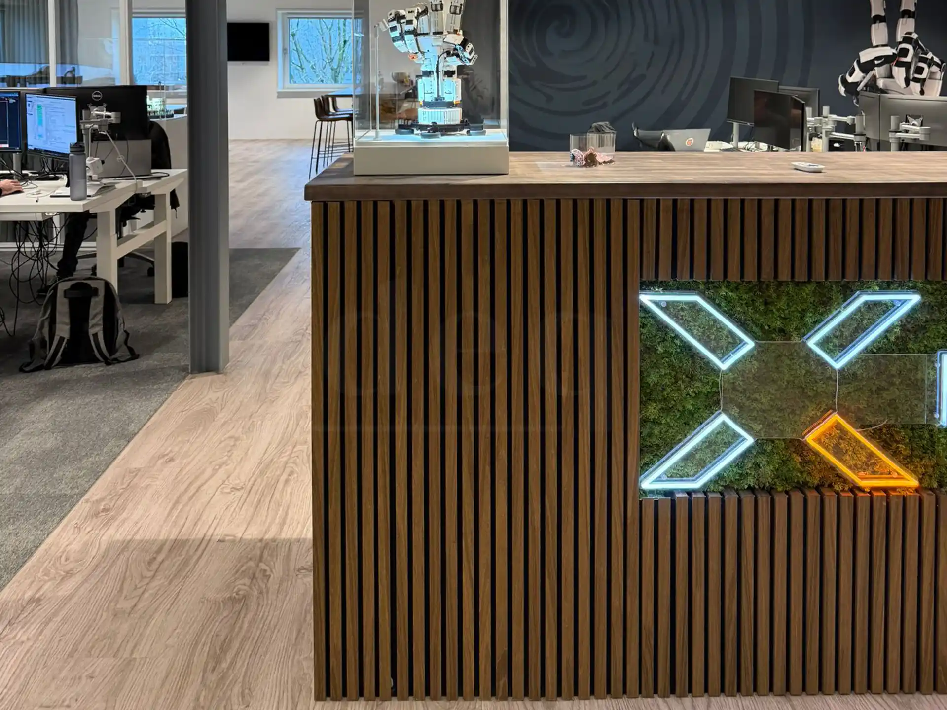 Kast bekleed met bruine eiken akoestische wandpanelen van Adeqo, voorzien van geïntegreerde ledverlichting en een decoratief mosaccent.