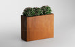 Strakke cortenstalen plantenbak van 100x40x80 cm met compacte groene planten en roze bloemetjes, gefotografeerd tegen een neutrale achtergrond.