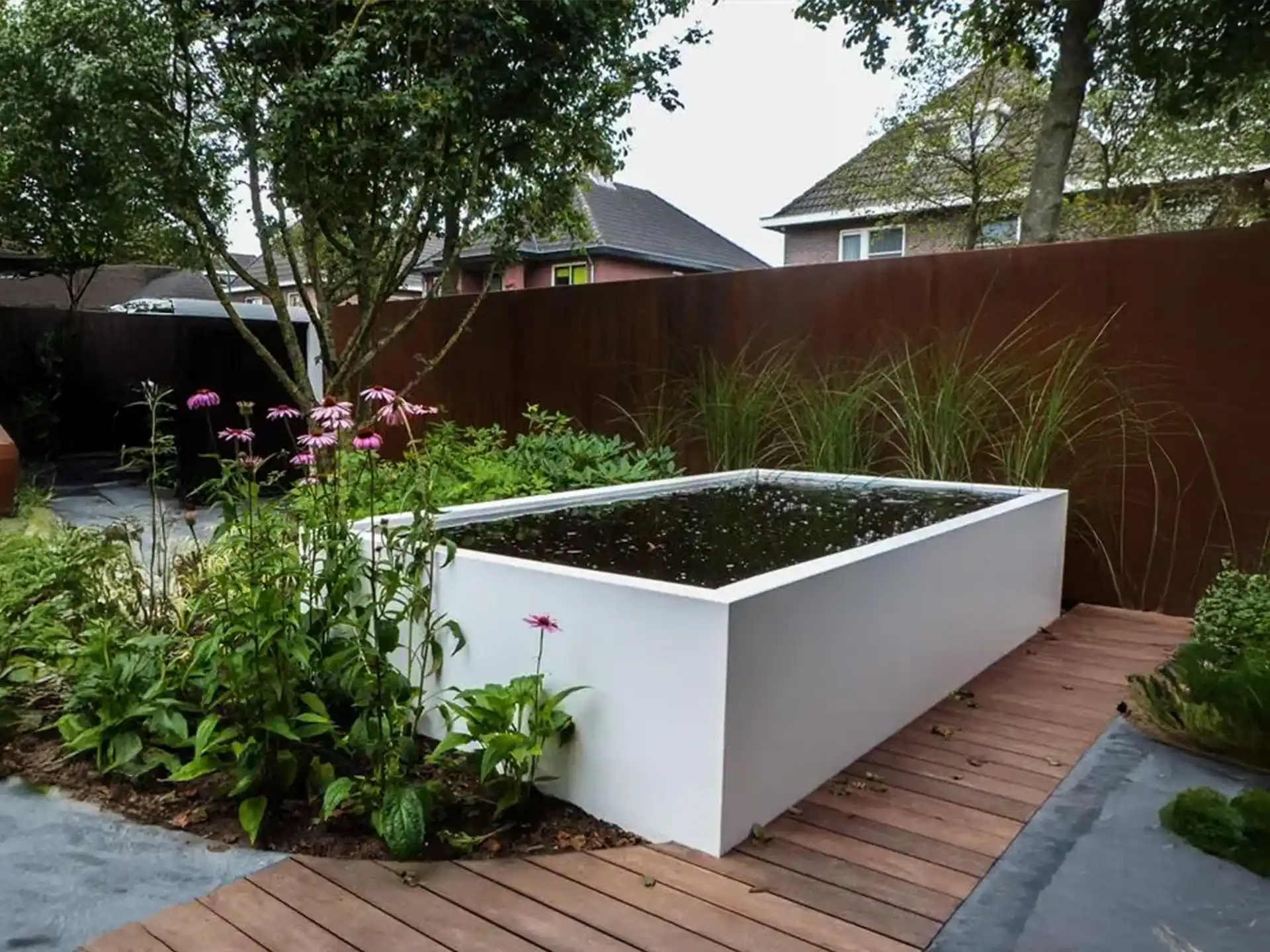 Adezz aluminium vijver geïntegreerd in een bloementuin, rechthoekig design met helder water, luxe tuininrichting.