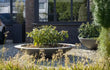 Adezz Ceder polyester plantenbak rond schaalmodel met groene planten en sierlijke uitstraling in de tuin.