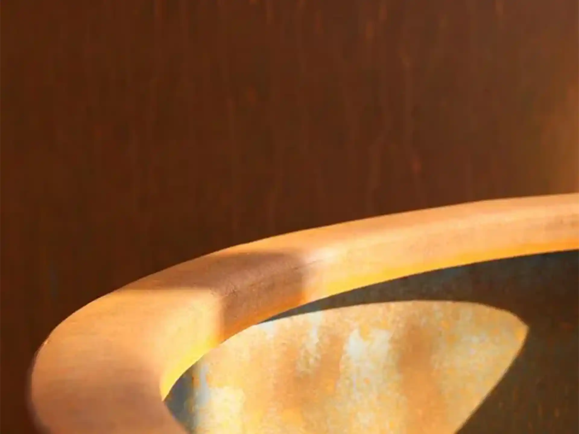 Close-up van de rand van een Adezz Conic Cortenstaal Plantenbak Rond met bodem, detail van het cortenstaal materiaal.