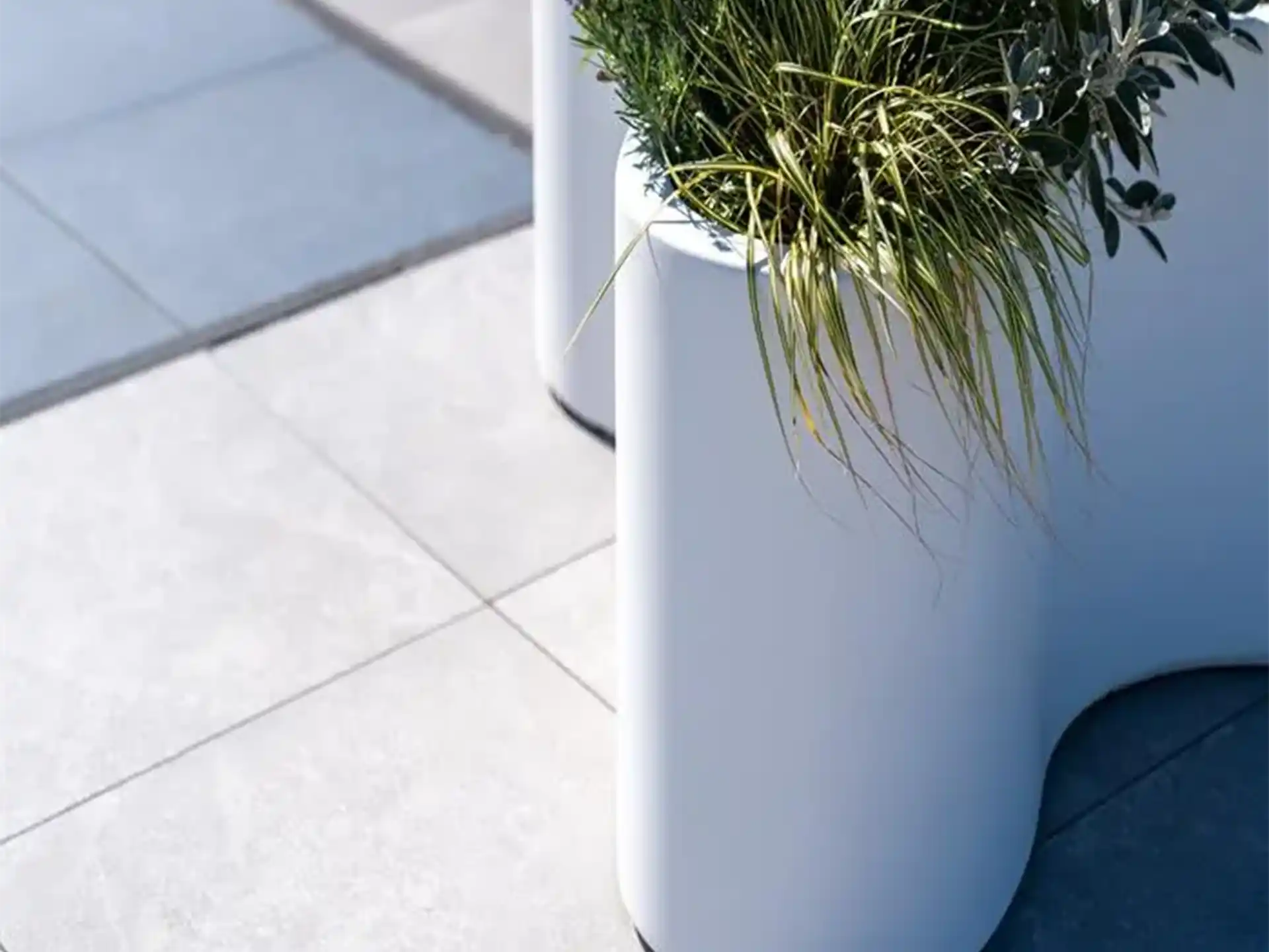 Detail van Adezz Organ polyester plantenbak rond organisch model in wit met groene beplanting.