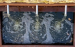 Close-up van drie waterstralen uit een cortenstaal Adezz vijvermuur, geplaatst op vijver met pomp, rustgevend waterornament in tuin.