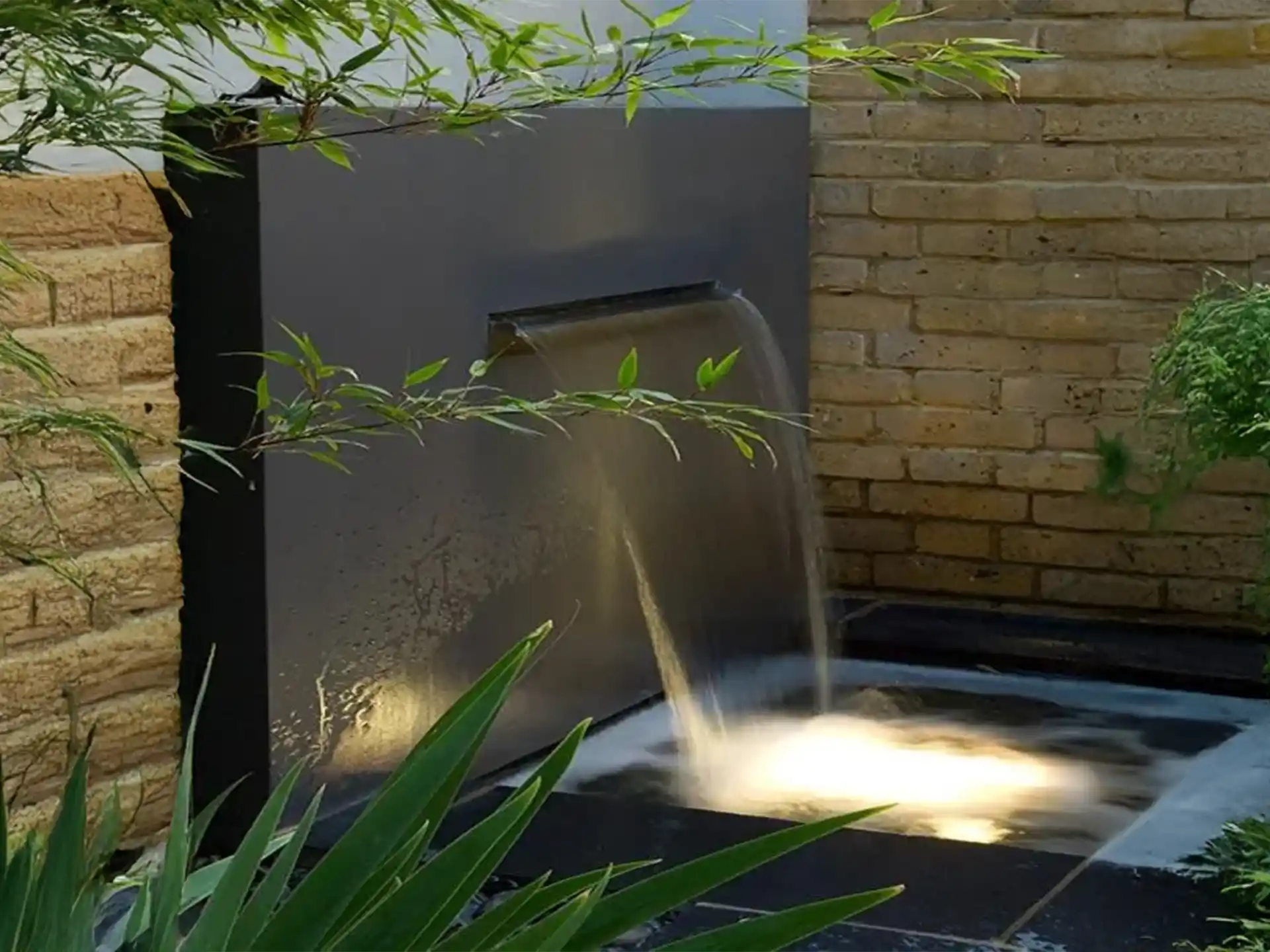 Adezz vrijstaande vijvermuur van aluminium met geïntegreerde waterval en pomp, strak modern tuinontwerp.