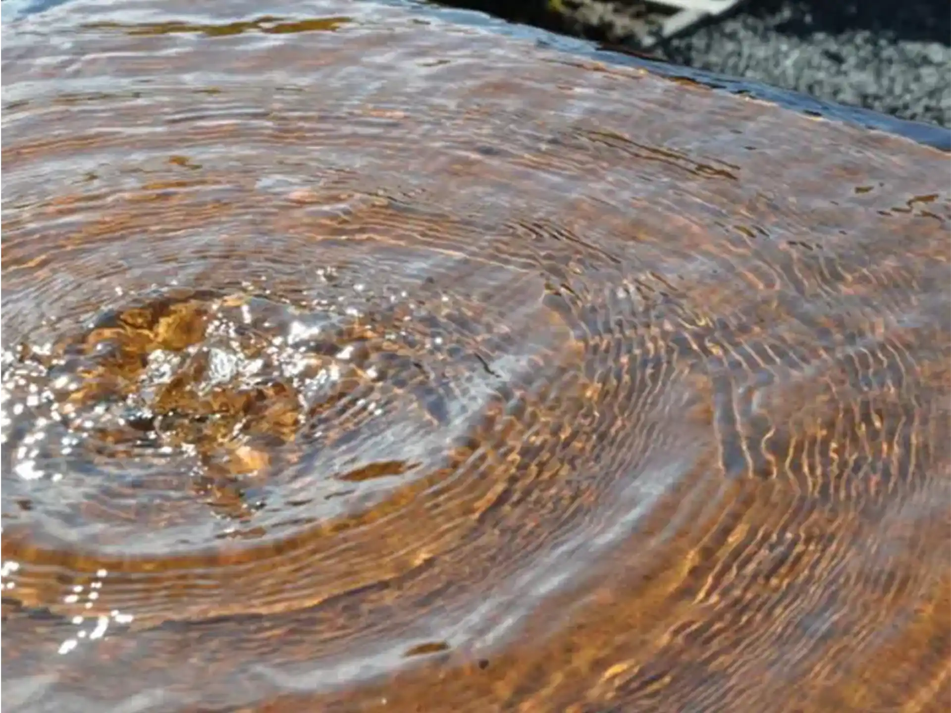 Detail van het Adezz waterblok cortenstaal met drie fonteinen, close-up van het stromende wateroppervlak.