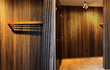 Akoestische wandpanelen van gerookt eiken in een luxe hal met verticale lattenstructuur