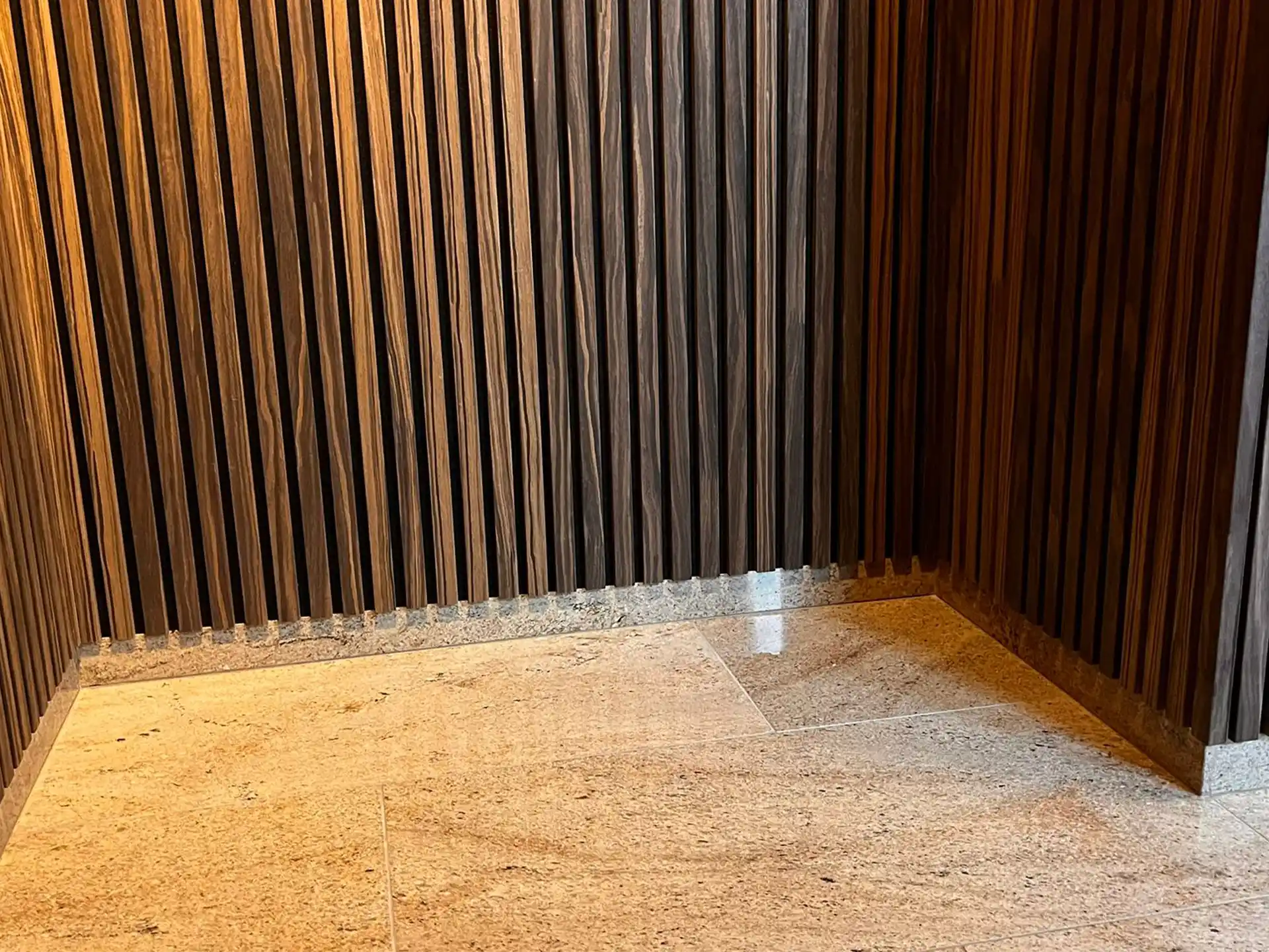 Hoekopstelling van akoestische wandpanelen in gerookt eiken met strakke afwerking