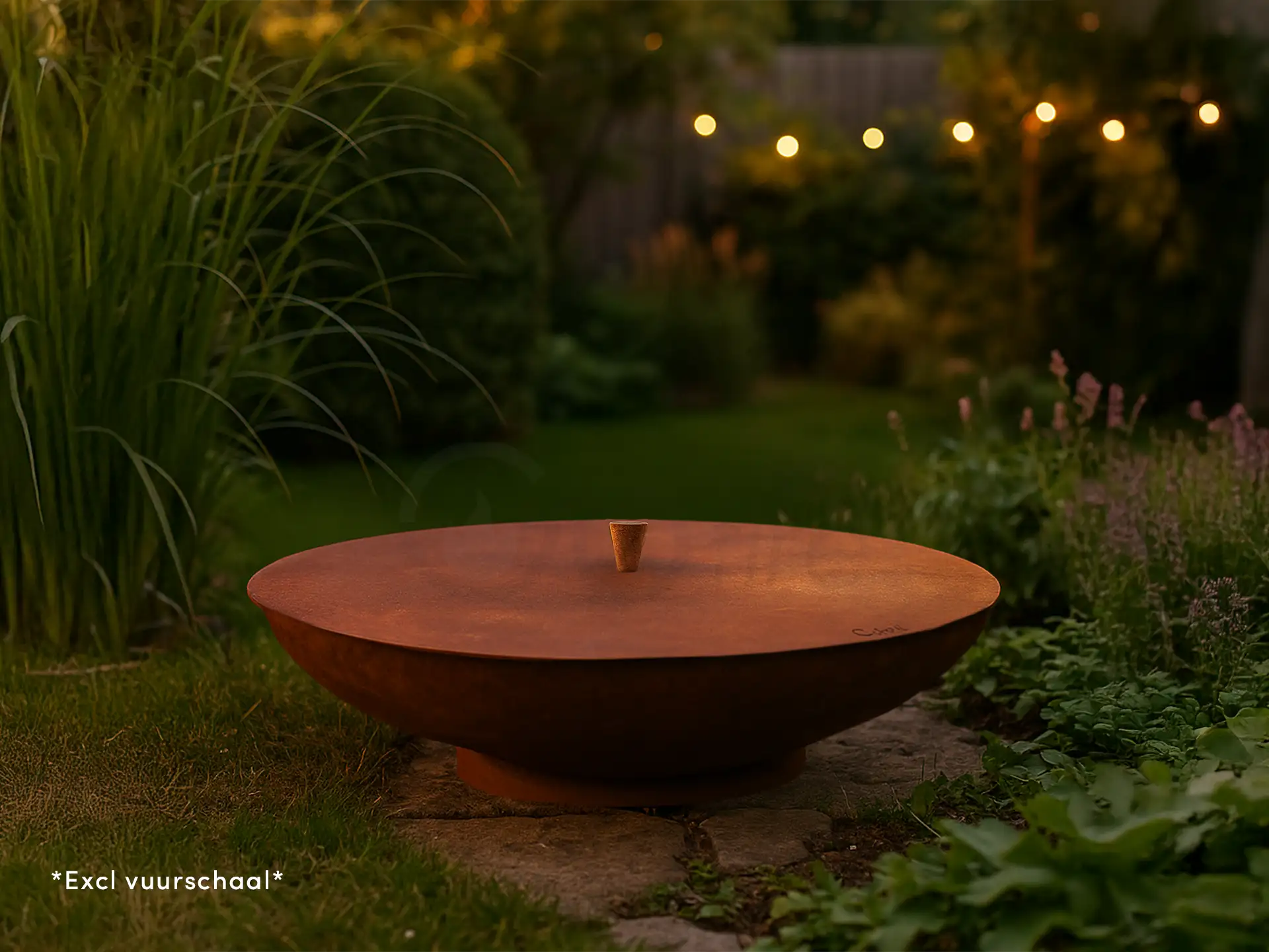 Gofire deksel van cortenstaal voor vuurschaal in een sfeervolle tuin bij schemering, omringd door gras en beplanting, met warme tuinverlichting op de achtergrond die een gezellige ambiance creëert.