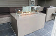 Gofire inbouwbrander 56 × 28 cm ingebouwd in moderne vuurtafel van betonlook, geplaatst op overdekt terras.