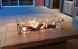 Gofire rechthoekige inbouwbrander 56 × 28 cm met glasombouw, geplaatst op houten tafel met vlammenspel.
