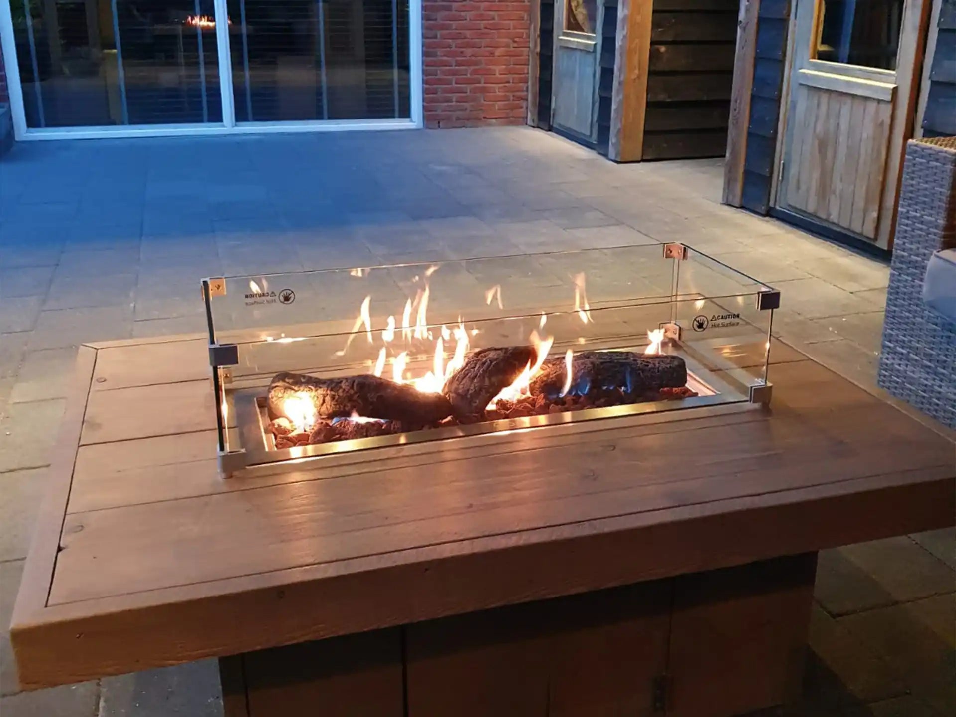 Gofire rechthoekige inbouwbrander 56 × 28 cm met glasombouw, geplaatst op houten tafel met vlammenspel.