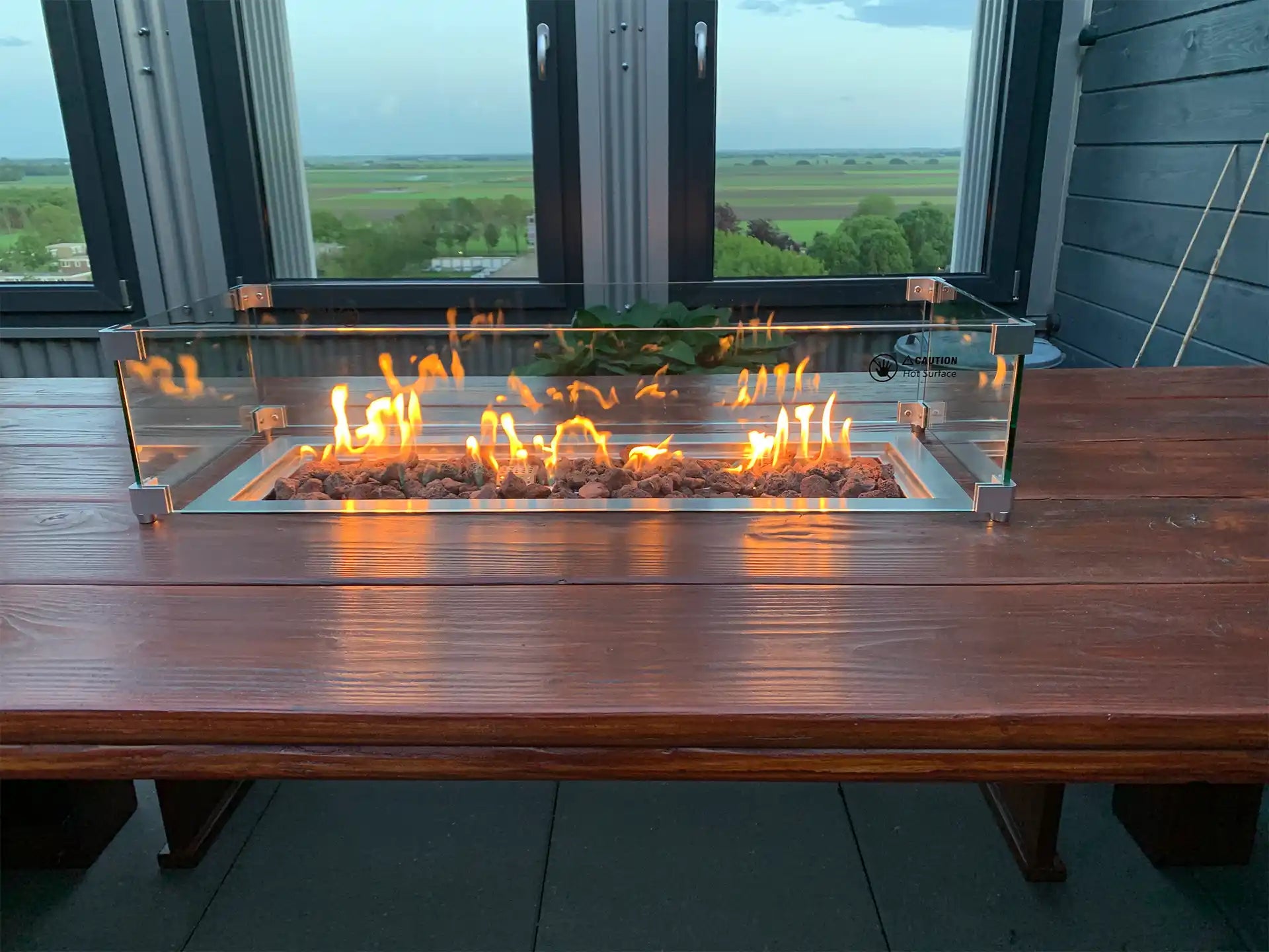 Gofire inbouwbrander 56 × 28 cm brandend in houten vuurtafel op terras, sfeervol gebruik in de avond.