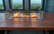 Gofire inbouwbrander 79 × 36 cm met glasombouw, geplaatst op houten tafel met panoramisch uitzicht, vlammen sfeervol brandend.