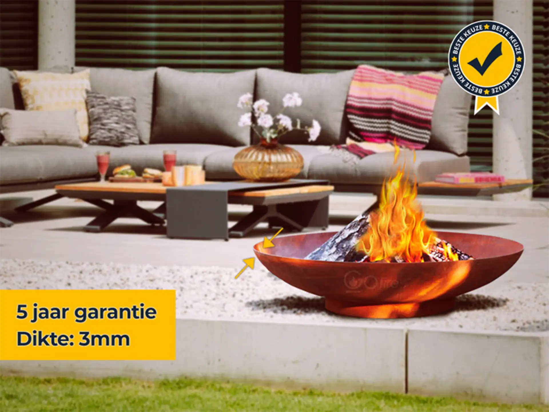 GoFire soho vuurschaal van cortenstaal met brandend hout, geplaatst in een moderne tuin met lounge set en decoratie, ideaal voor sfeervolle avonden.