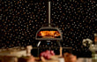Ooni Karu 2 Pro hout- of houtskoolgestookte pizza oven, close-up met pizza in de oven en sfeervolle achtergrond.