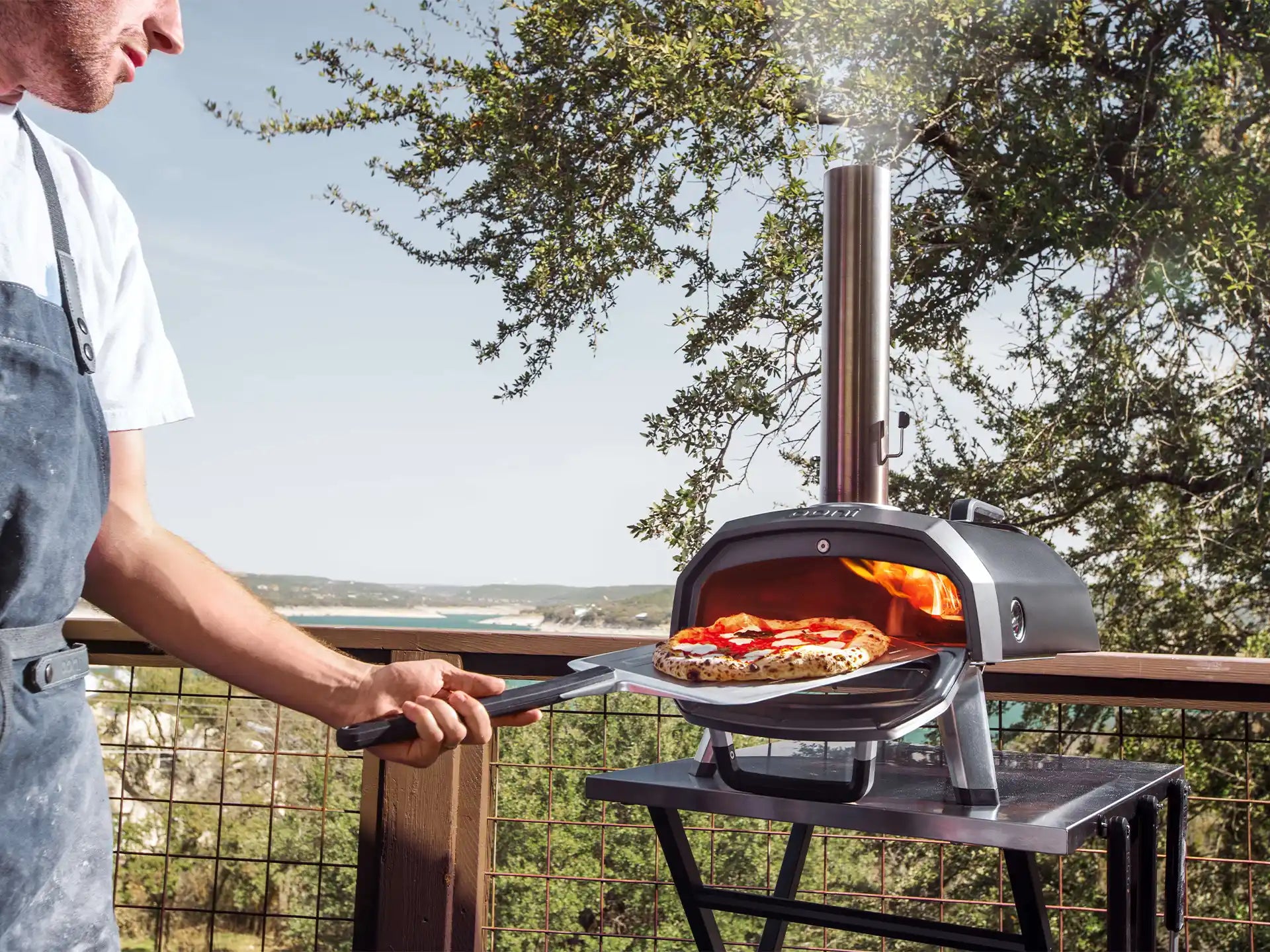 Ooni Karu 2 Pro pizza oven hout of houtskool gestookt, geplaatst buiten met pizza die bakt in de oven.
