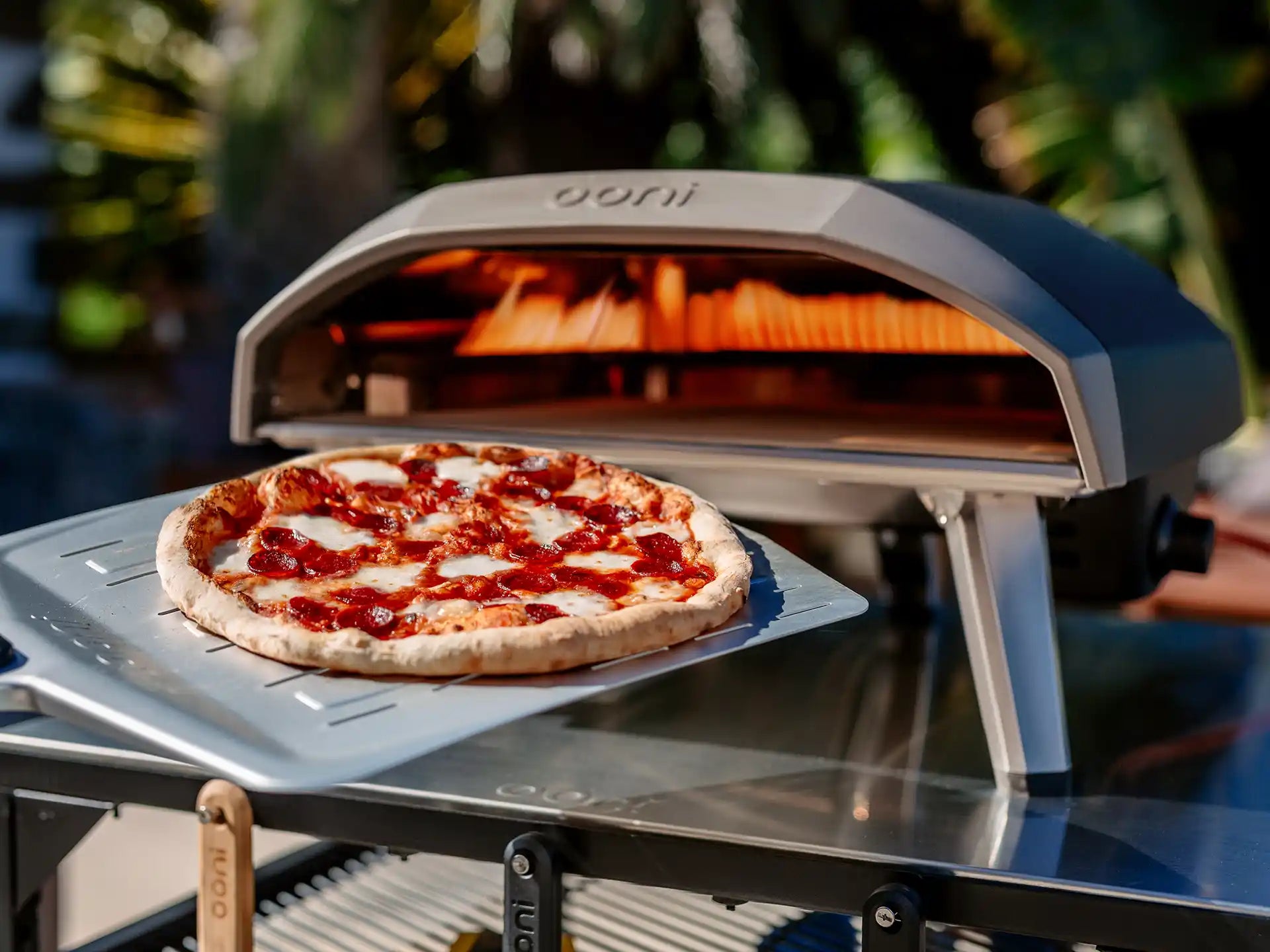 Ooni Koda 12 pizza oven buiten in gebruik, close-up van pizza die bakt in de oven.