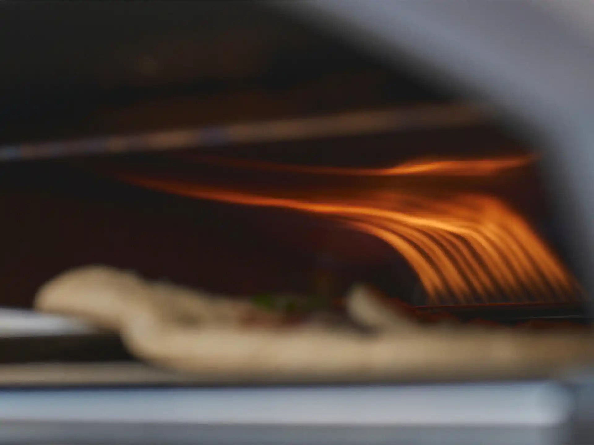 Ooni Koda 2 pizza oven gasgestookt, close-up van de vlam tijdens het bakken van pizza in de oven.