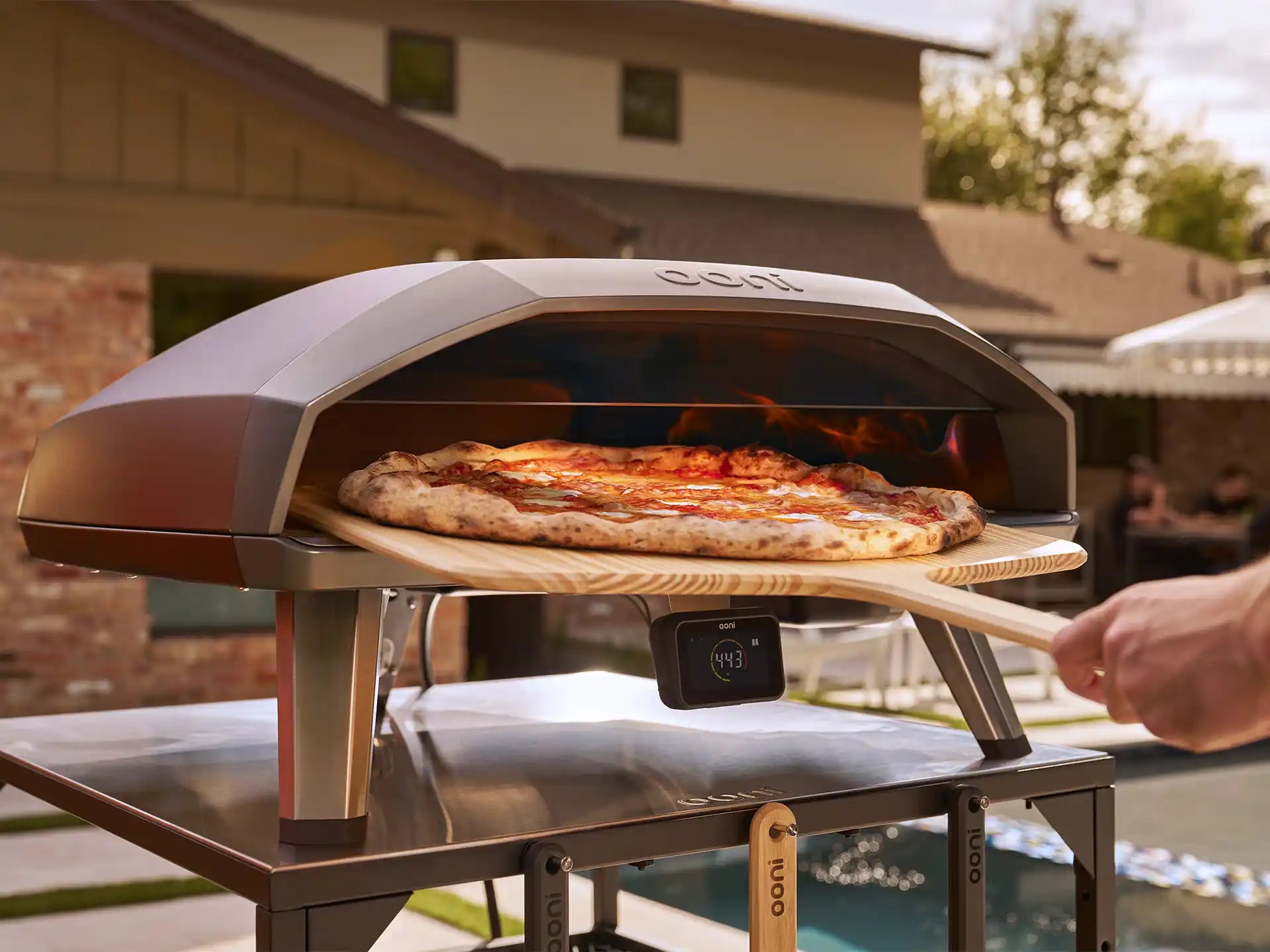 Ooni Koda 2 Max gasgestookte pizza oven in gebruik buiten, pizza bakt in de oven met zichtbare vlam.