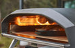 Ooni Koda 2 Pro pizza oven op gas, close-up van pizza die bakt in de oven met zichtbare vlam.
