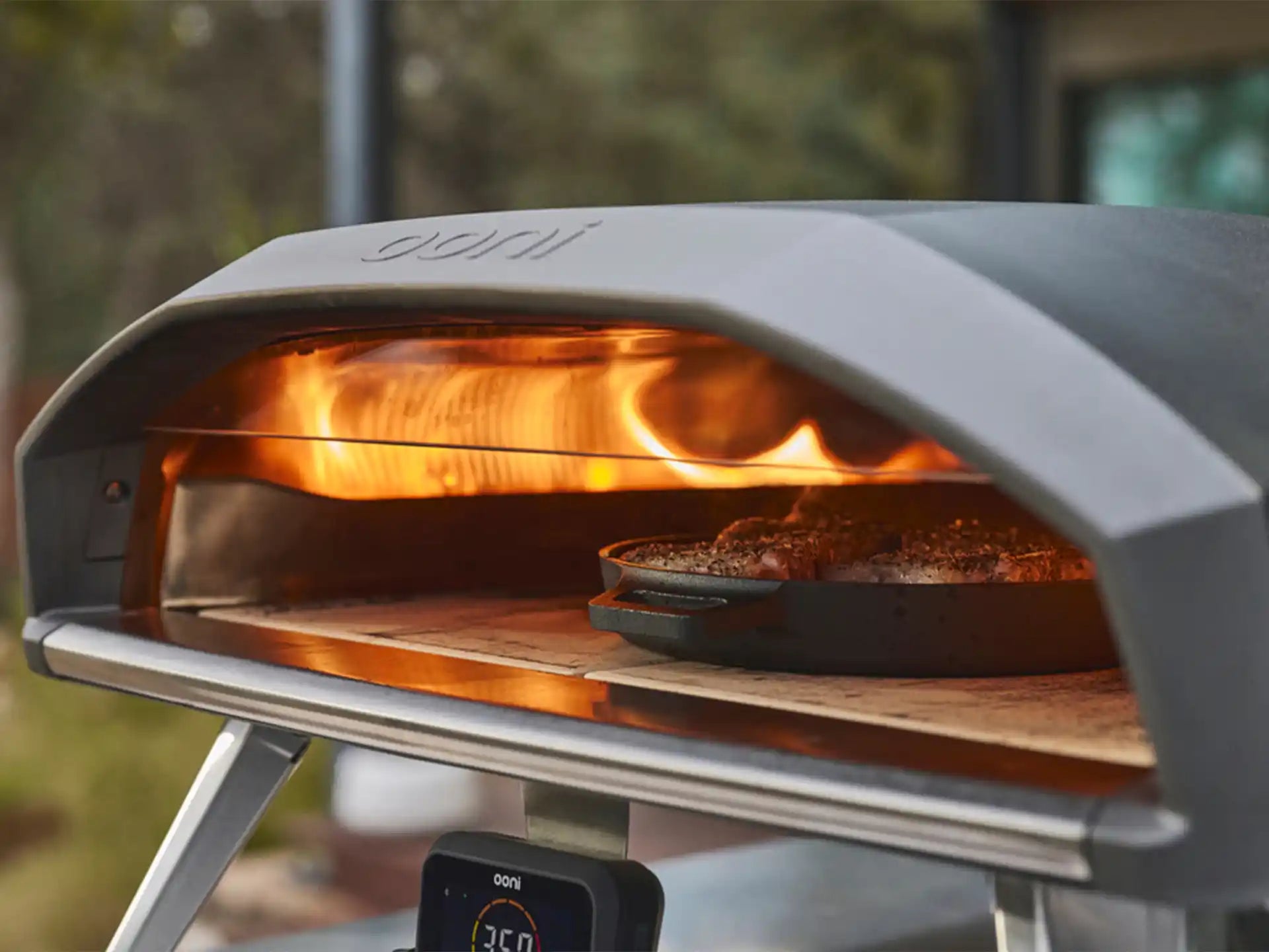 Ooni Koda 2 Pro pizza oven op gas, close-up van pizza die bakt in de oven met zichtbare vlam.
