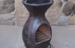 Sfeerfoto van het Sol-y-Yo Chimenea grillrooster, geplaatst op de Mexicaanse terrashaard / BBQ (46 x 106 cm), gebruikt voor het bereiden van gerechten boven brandend vuur in een sfeervolle tuinomgeving.