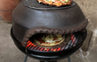 Sol-y-Yo Pizza Dome stenen koepeloven ø54 cm, in gebruik op barbecue, pizza wordt gebakken boven houtskoolvuur.