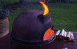 Sol-y-Yo Toscaanse houtgestookte pizza oven 52 cm, buiten geplaatst op tafel, met brandend vuur in de oven.