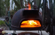Sol-y-Yo Toscaanse stenen pizza oven houtgestookt, 52 cm, close-up van brandend vuur in de ovenopening.