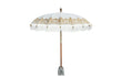 Crème Bali parasol met half gouden beschildering en witte franjes, recht van voren op parasolvoet.