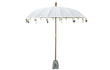 Productfoto van de Todo Bien Bali parasol crème, volledig geopend met houten stok en decoratieve hangers, op een witte achtergrond.