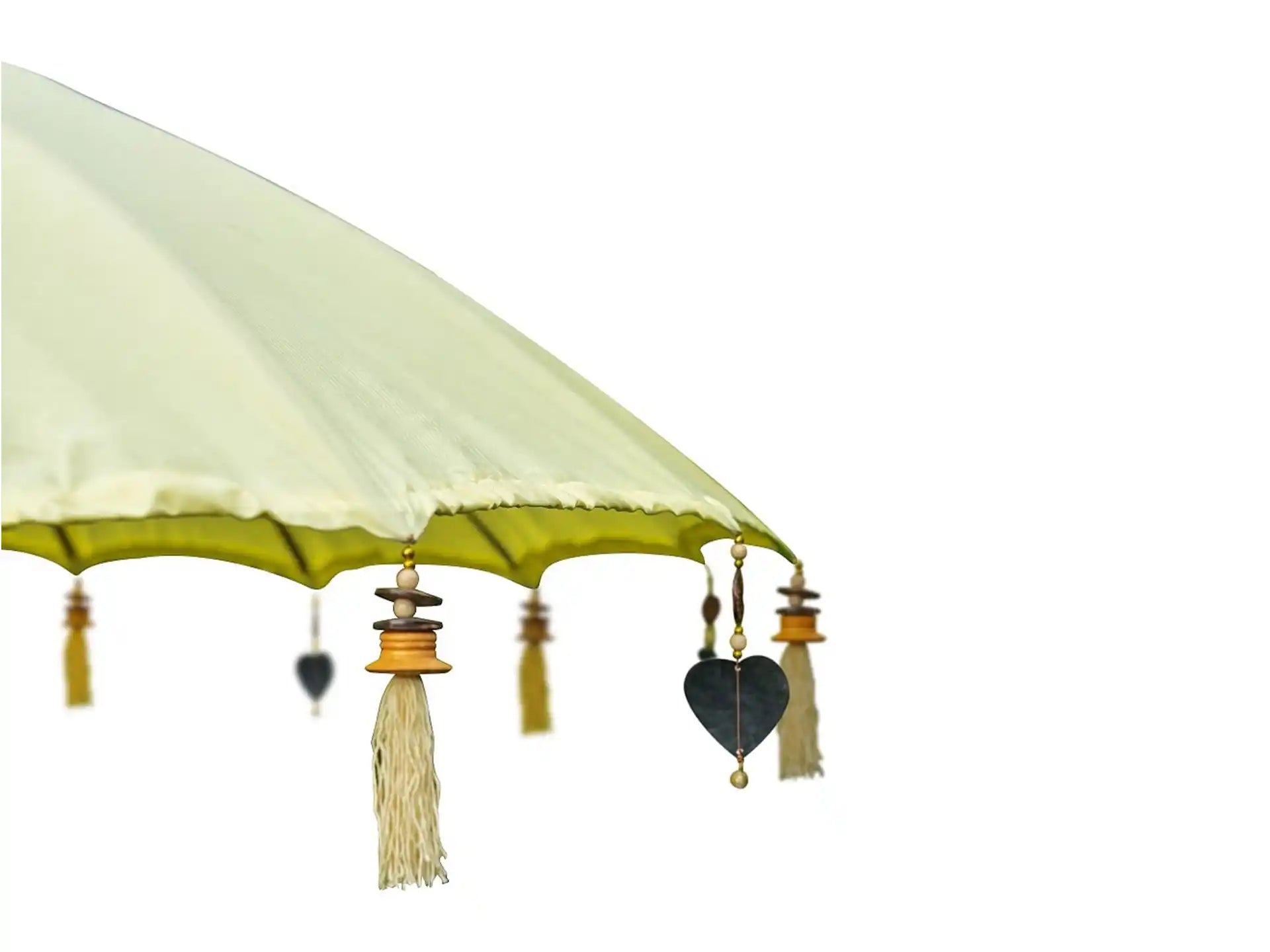 Detail van de Todo Bien Bali parasol geel met hangende hartvormige ornamenten en kwastjes langs de rand.