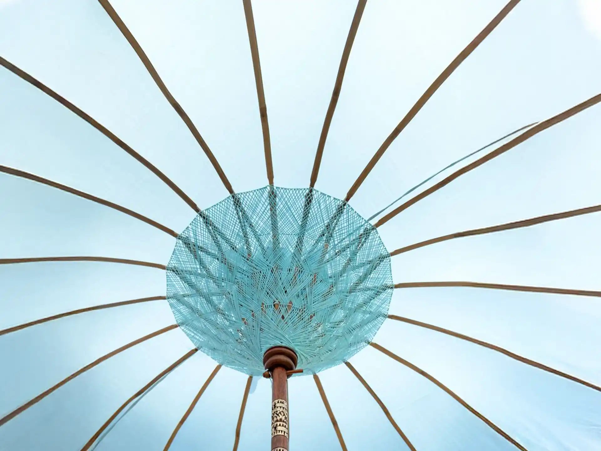 Binnenaanzicht van de lichtblauwe Todo Bien Bali parasol met handgeweven touwconstructie en houten baleinen, traditioneel Balinees vakmanschap.