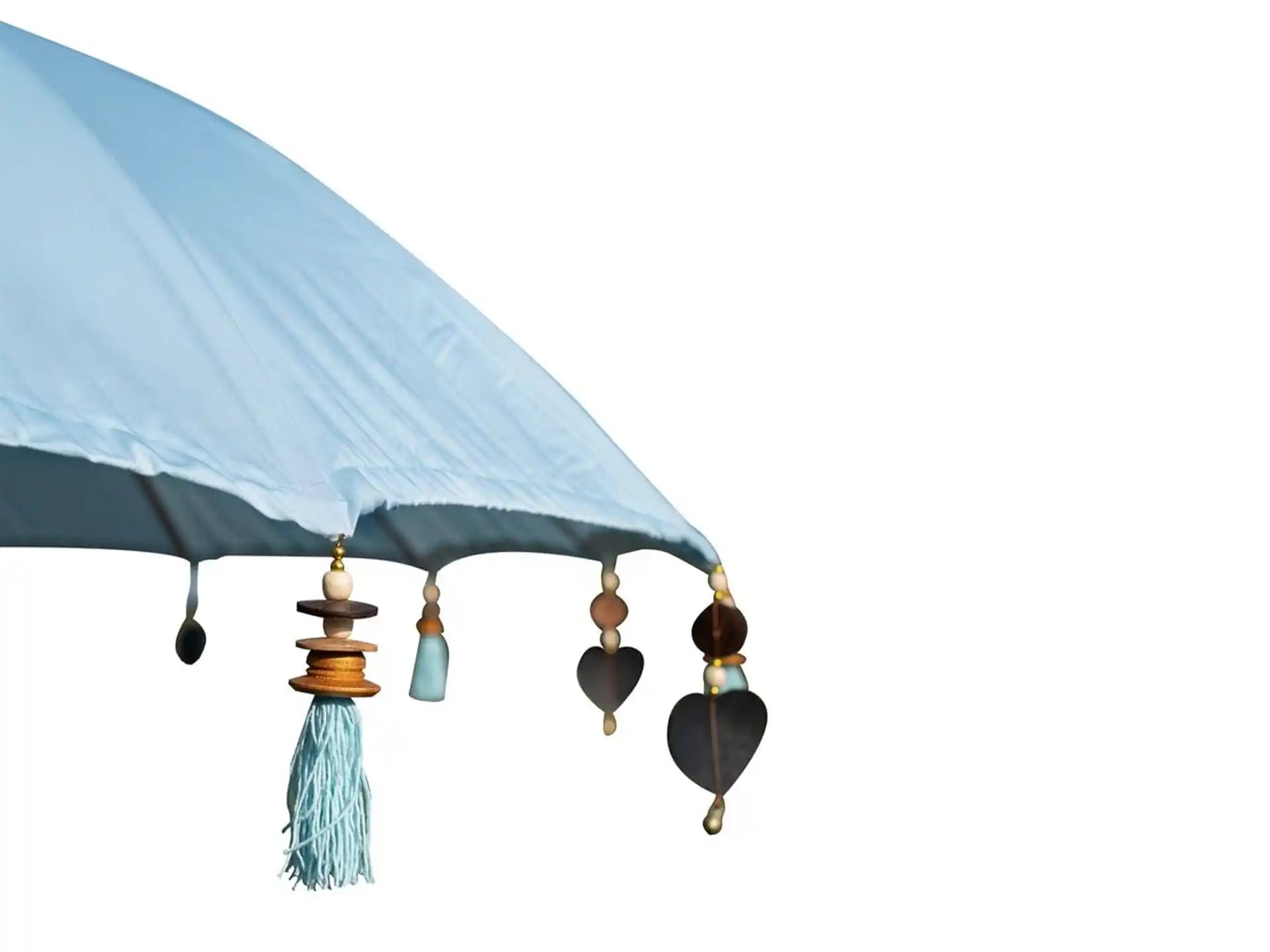 Close-up van de lichtblauwe Todo Bien Bali parasol met houten kralen, metalen hartjes en decoratieve kwastjes langs de rand, ideaal als luxe tuinparasol.