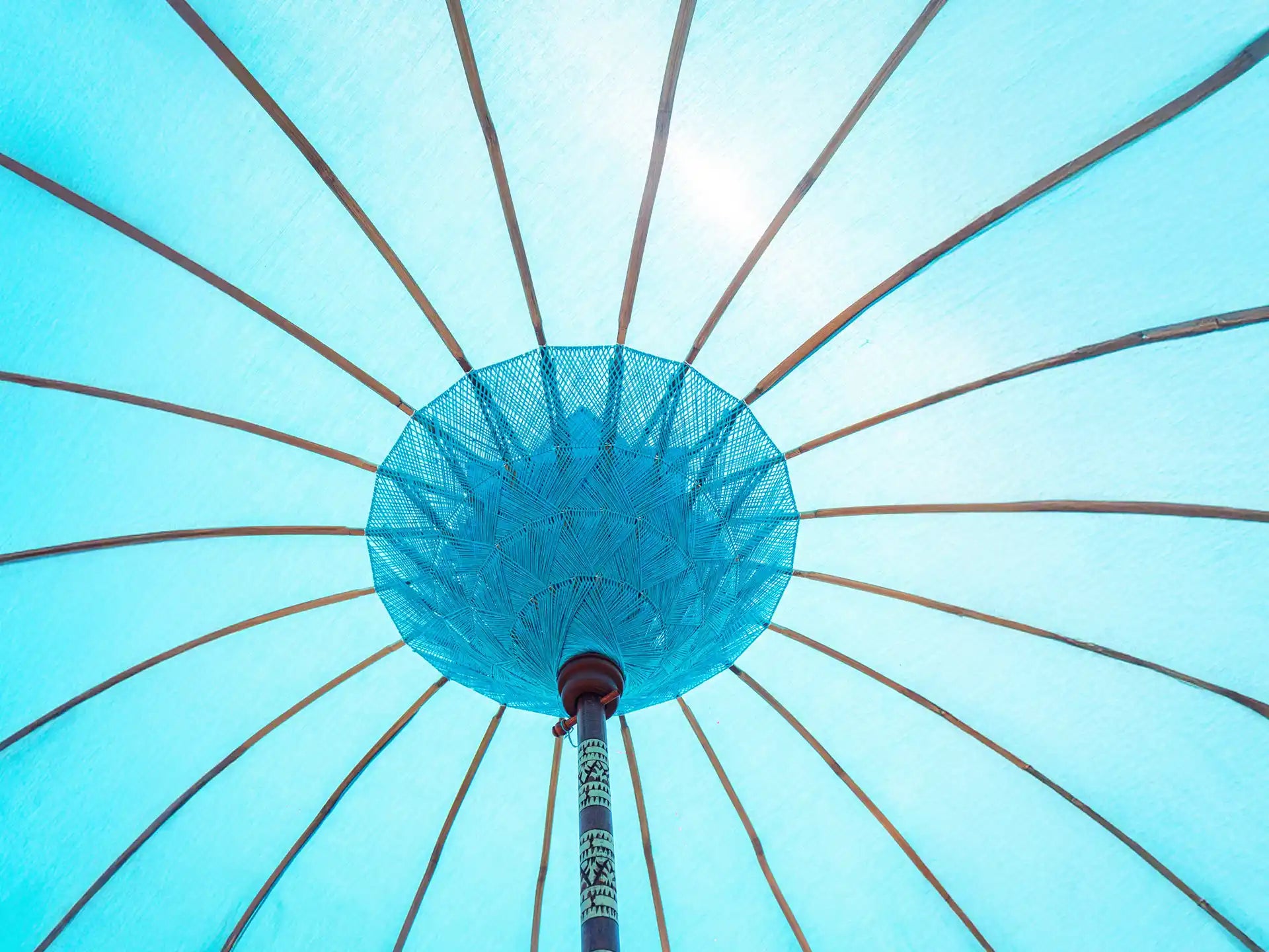 Detail van de binnenkant van de Todo Bien Bali parasol in zeeblauw, met houten baleinen en traditioneel geweven middenstuk dat zorgt voor een authentieke Balinese uitstraling.
