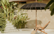 Detail van de Todo Bien Bali Parasol Zwart met handgemaakte versieringen, houten stok en elegante afwerking voor een authentieke Balinese sfeer.